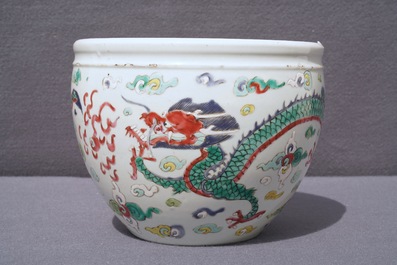 A Chinese blue and white fish bowl and a famille rose 'dragon' jardini&egrave;re, 19th C. and Yongzheng